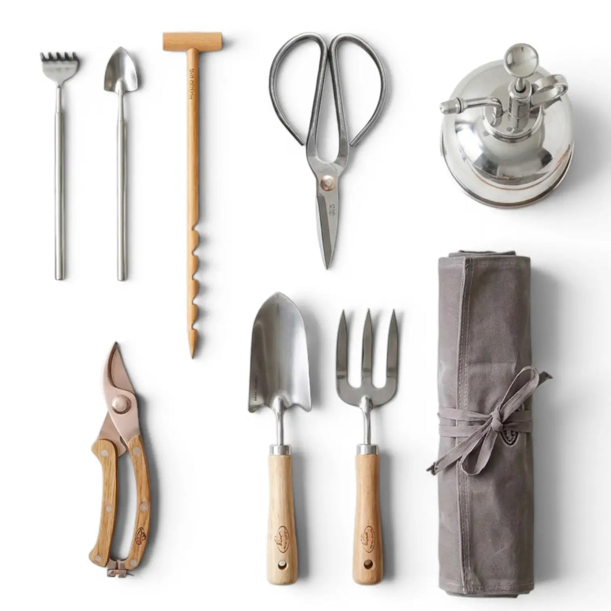 Plant care tools and accessories: small rake and shovel, bonsai scissors, mister, prunning shears, flatlay on white background