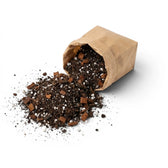 Brown paper bag filled with aroid potting mix on a white background