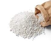 Perlite spilling from a brown paper bag on a white background